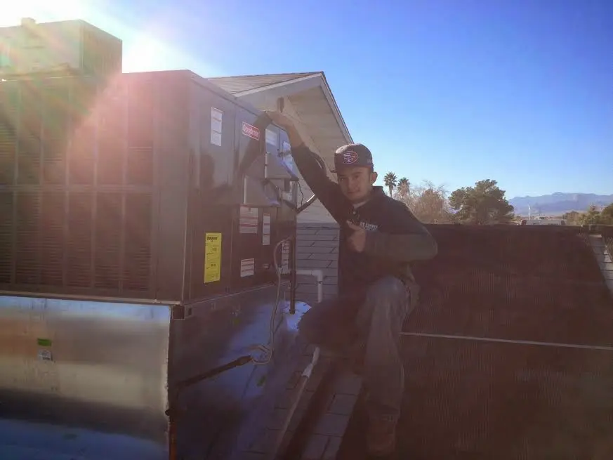 HVAC technician performing AC Tune-Up on a rooftop unit in Five Corners